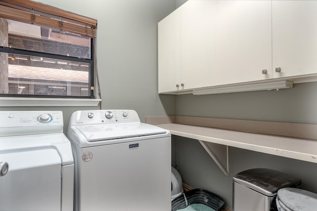 washroom with cabinet space and washer and dryer