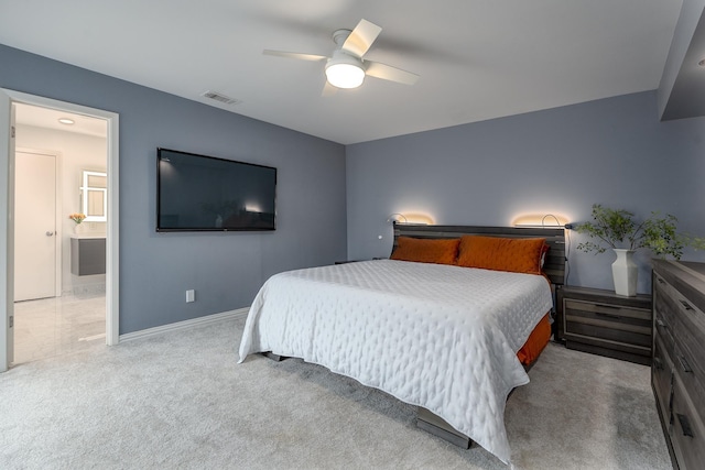 bedroom with visible vents, baseboards, light colored carpet, ceiling fan, and ensuite bathroom