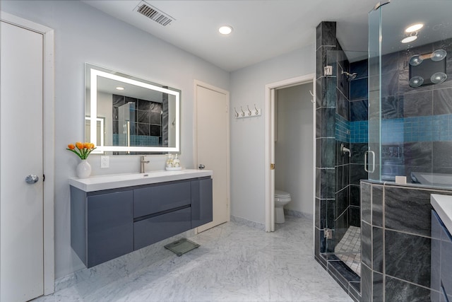 bathroom with marble finish floor, visible vents, toilet, a stall shower, and vanity