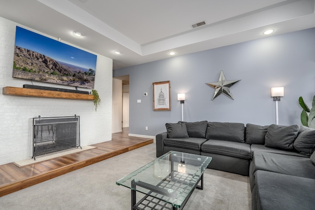 carpeted living room featuring baseboards, a fireplace, visible vents, and recessed lighting