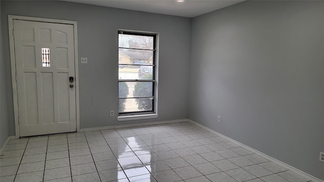 foyer with light tile patterned floors, baseboards, and a healthy amount of sunlight