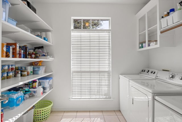 laundry area with laundry area, light tile patterned floors, and washing machine and clothes dryer