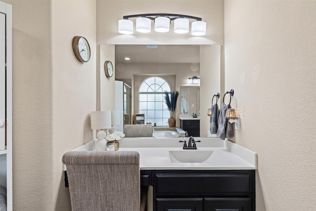 bathroom featuring a textured wall and vanity