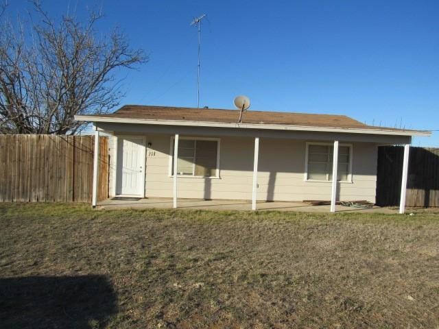 back of property featuring a yard and fence