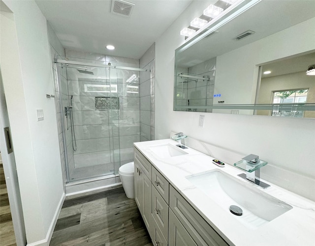 bathroom with toilet, a sink, and visible vents