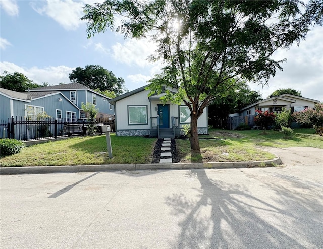 view of front of house with a residential view, fence, and a front yard