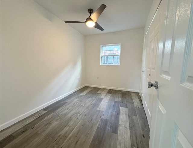 unfurnished bedroom featuring ceiling fan, dark wood-type flooring, and baseboards