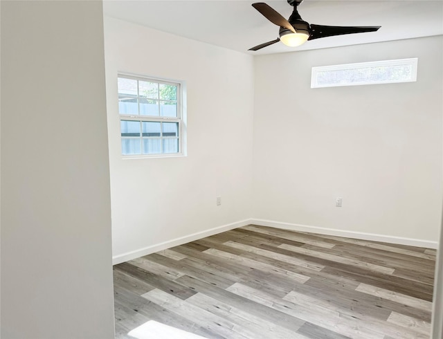 empty room with light wood-style floors, a healthy amount of sunlight, ceiling fan, and baseboards