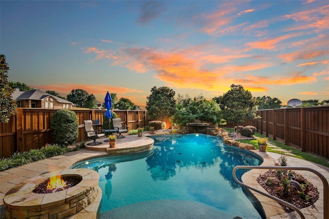 pool at dusk featuring a fire pit, a fenced backyard, and a fenced in pool