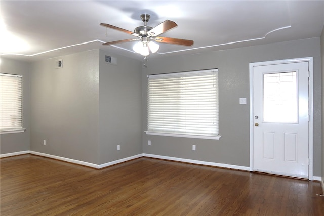 interior space featuring visible vents, wood finished floors, a ceiling fan, and baseboards