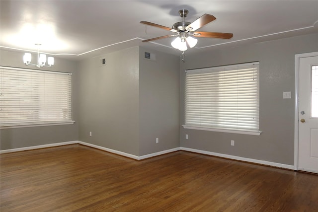 interior space featuring ceiling fan with notable chandelier, wood finished floors, visible vents, and baseboards