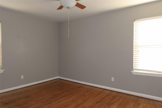 empty room featuring ceiling fan, baseboards, and wood finished floors