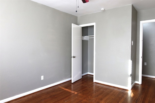 unfurnished bedroom featuring a closet, ceiling fan, baseboards, and wood finished floors