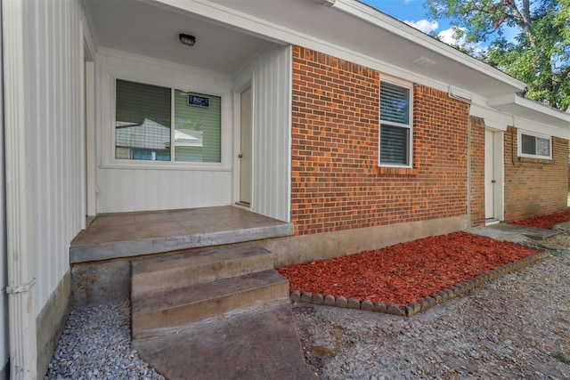 doorway to property featuring brick siding