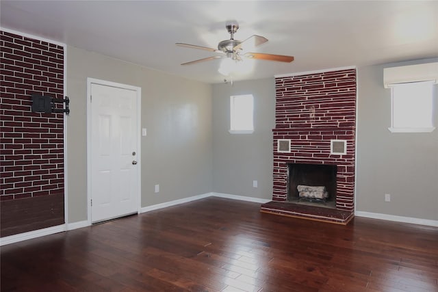 unfurnished living room with an AC wall unit, wood-type flooring, and a fireplace