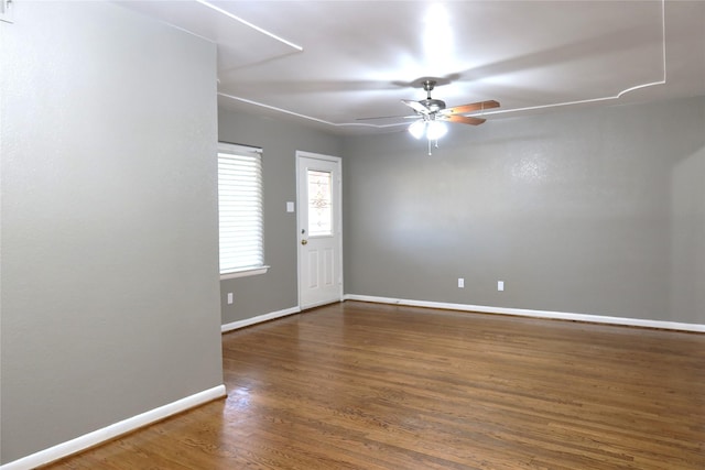 unfurnished room with a ceiling fan, baseboards, and wood finished floors