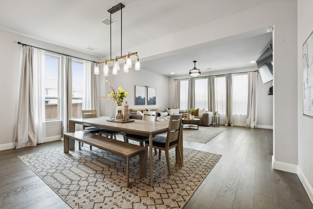 dining area with hardwood / wood-style floors, visible vents, and baseboards