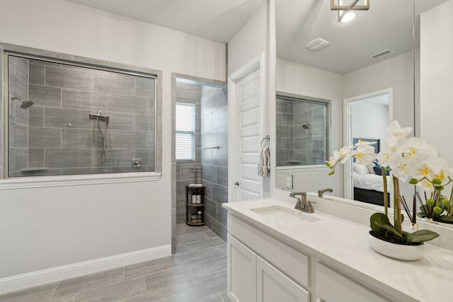 bathroom featuring visible vents, walk in shower, vanity, and baseboards