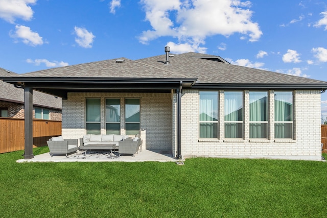 rear view of property with a yard, fence, an outdoor hangout area, and brick siding