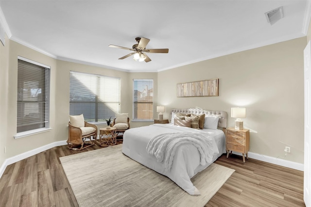 bedroom with baseboards, visible vents, ornamental molding, and wood finished floors