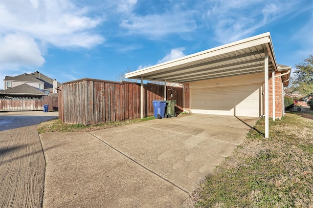 view of side of property with a garage, concrete driveway, brick siding, and a carport