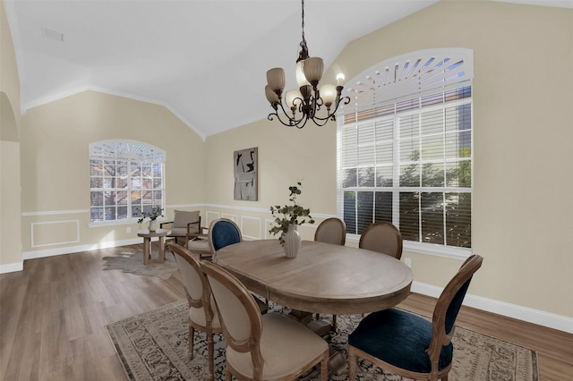 dining space with lofted ceiling, baseboards, a chandelier, and wood finished floors