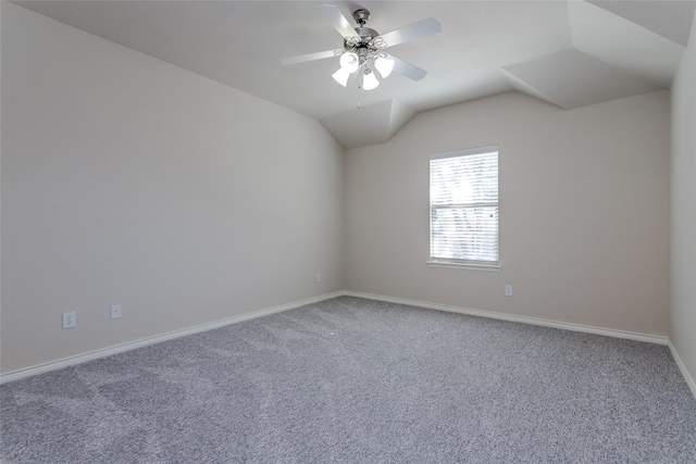 spare room featuring carpet floors, ceiling fan, baseboards, and vaulted ceiling