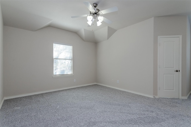 carpeted empty room with lofted ceiling, ceiling fan, and baseboards