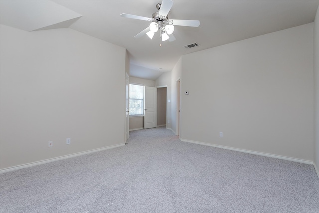 unfurnished room with light colored carpet, lofted ceiling, visible vents, and baseboards