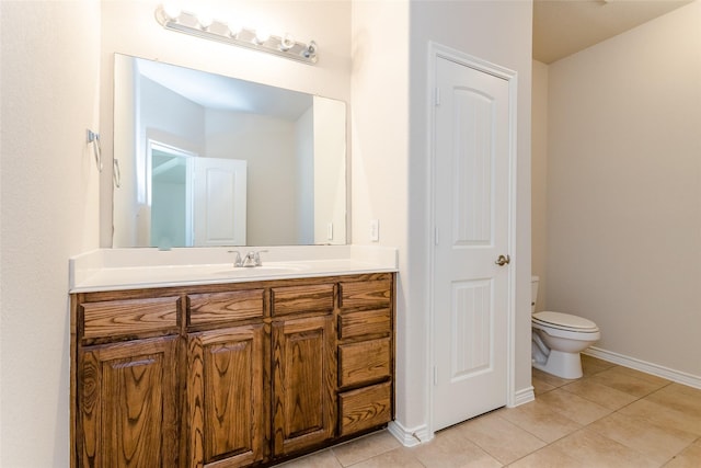 bathroom featuring a closet, toilet, vanity, tile patterned flooring, and baseboards