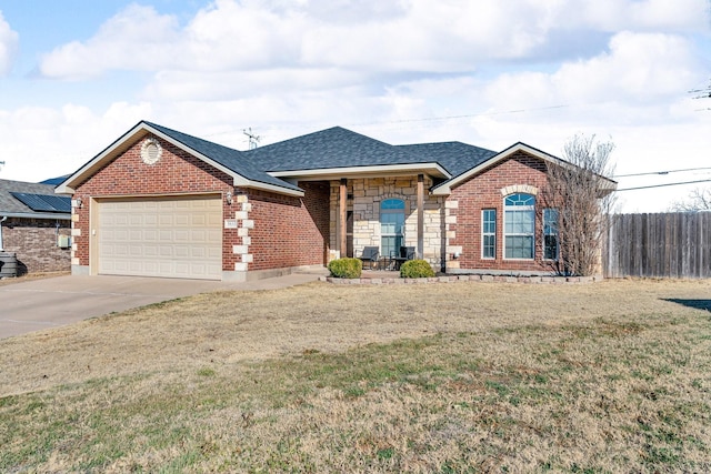 single story home featuring an attached garage, fence, driveway, stone siding, and a front lawn