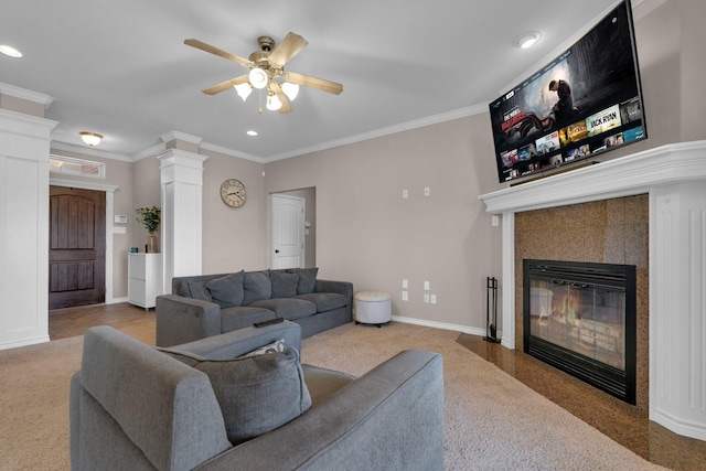 living room with ornamental molding, a tiled fireplace, decorative columns, and baseboards