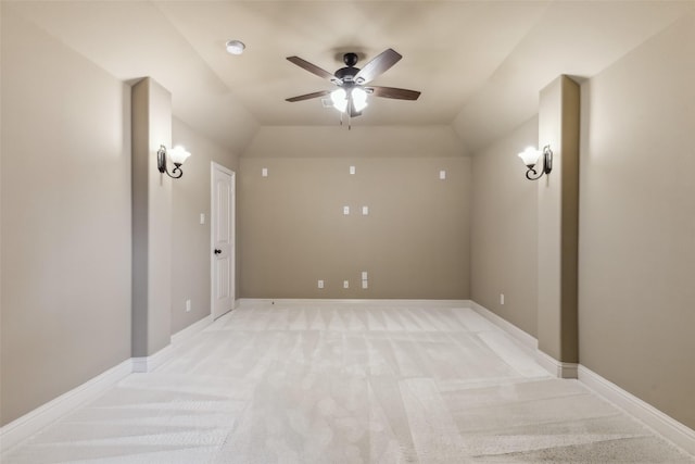 unfurnished room with lofted ceiling, ceiling fan, baseboards, and light colored carpet