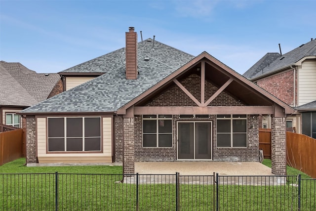 rear view of property with brick siding, a patio, roof with shingles, a lawn, and a fenced backyard