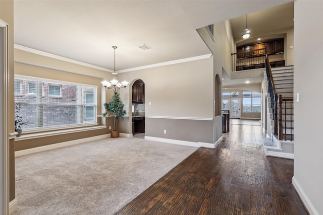 unfurnished dining area featuring baseboards, stairs, arched walkways, and a notable chandelier