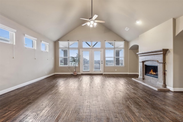 unfurnished living room featuring dark wood-type flooring, a high end fireplace, and baseboards