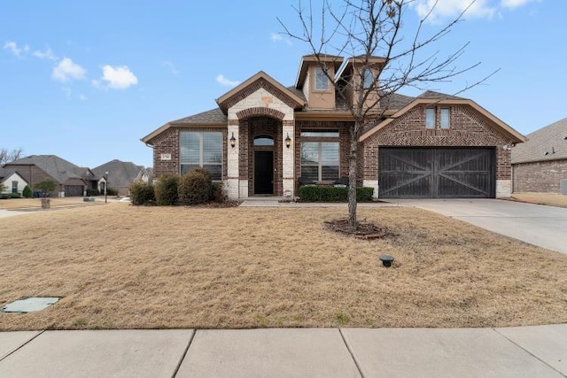 view of front facade with driveway, an attached garage, and brick siding