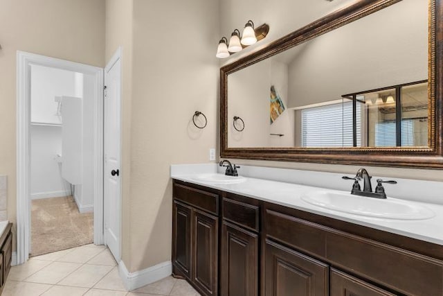 bathroom featuring tile patterned floors, a sink, baseboards, and double vanity