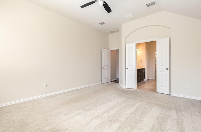 unfurnished bedroom with visible vents, vaulted ceiling, light carpet, and baseboards