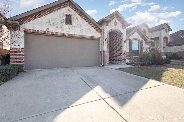 view of front of home with stone siding, concrete driveway, brick siding, and an attached garage