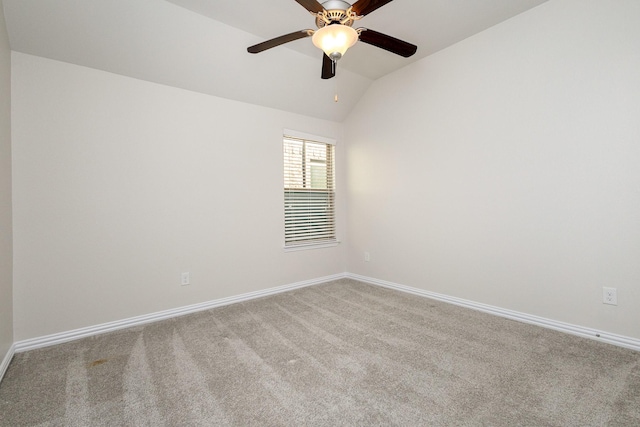 empty room with light carpet, vaulted ceiling, a ceiling fan, and baseboards