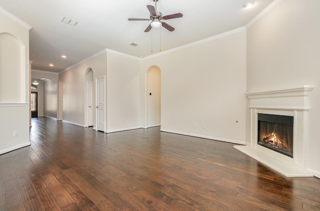 unfurnished living room featuring arched walkways, dark wood-style flooring, visible vents, baseboards, and a glass covered fireplace