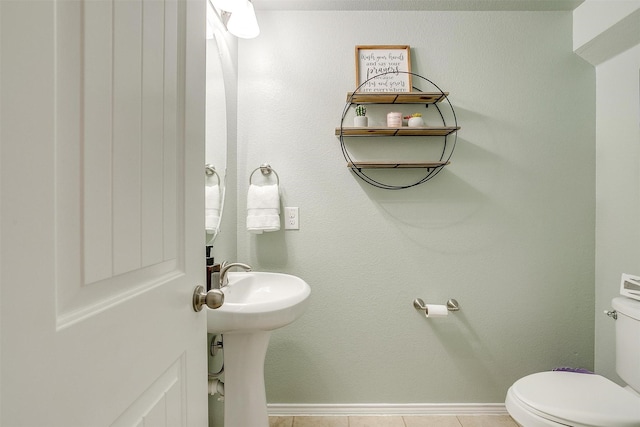 half bathroom featuring toilet and baseboards