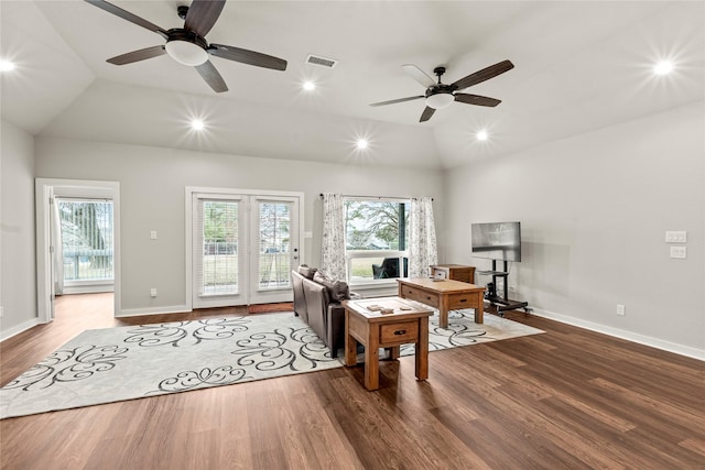 living room featuring lofted ceiling, baseboards, visible vents, and wood finished floors