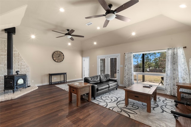 living area with visible vents, wood finished floors, a wood stove, vaulted ceiling, and recessed lighting