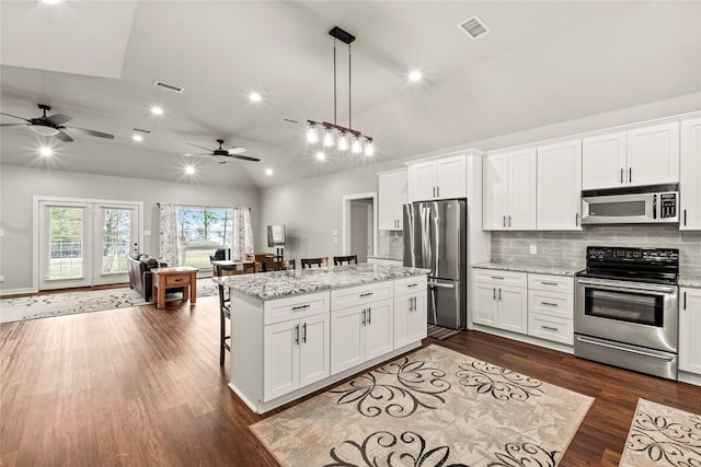 kitchen with white cabinets, stainless steel appliances, and open floor plan