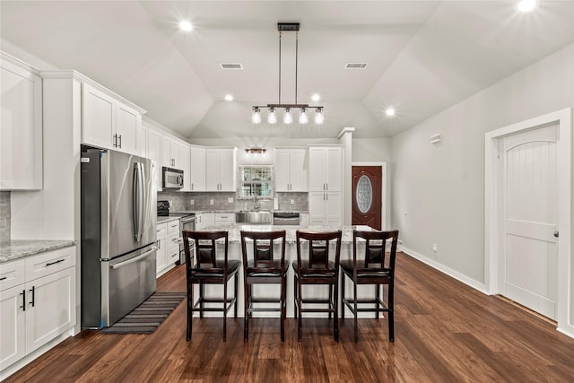 kitchen with appliances with stainless steel finishes, white cabinets, visible vents, and light stone countertops