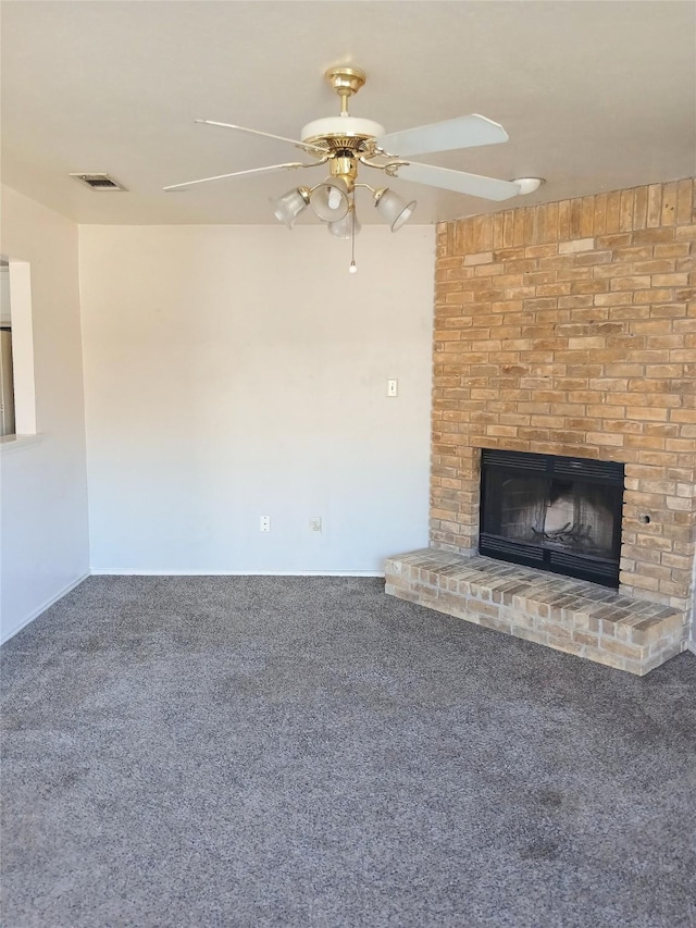 unfurnished living room with a brick fireplace, carpet flooring, visible vents, and a ceiling fan