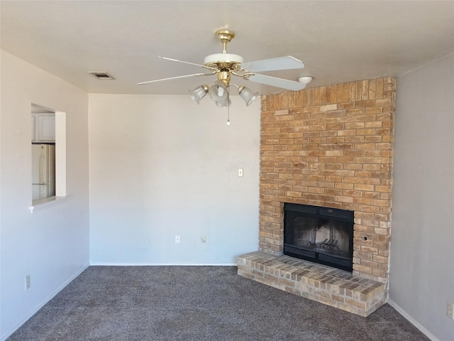 unfurnished living room with a brick fireplace, carpet, visible vents, and a ceiling fan