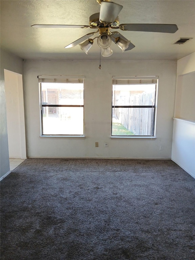 unfurnished room featuring a textured ceiling, ceiling fan, visible vents, and light colored carpet